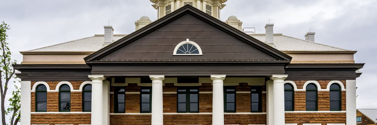 The front of a county courthouse built of brown stone, with white columns and a dark gabled portico, the legal setting a forensic psychologist works in.