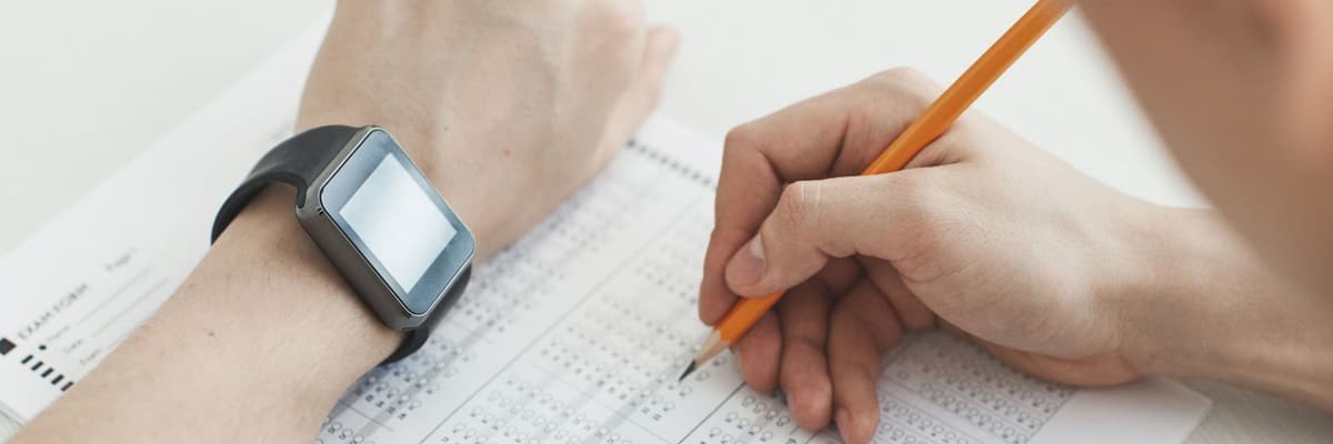 A hand with a pencil filling in a multiple-choice answer sheet, for EPPP pass rates.