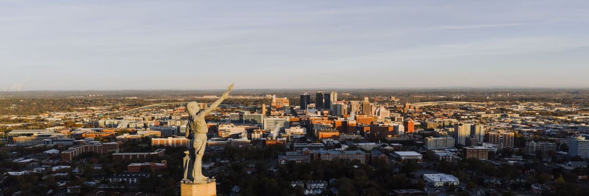 Aerial view of the Vulcan statue on its hill above the Birmingham, Alabama skyline at sunset