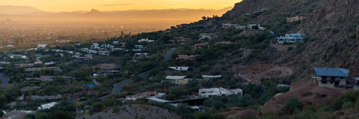 Homes on a desert hillside above Phoenix, Arizona, in the glow of sunset