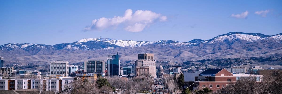 Downtown Boise, Idaho, with mountains behind it under a clear blue sky