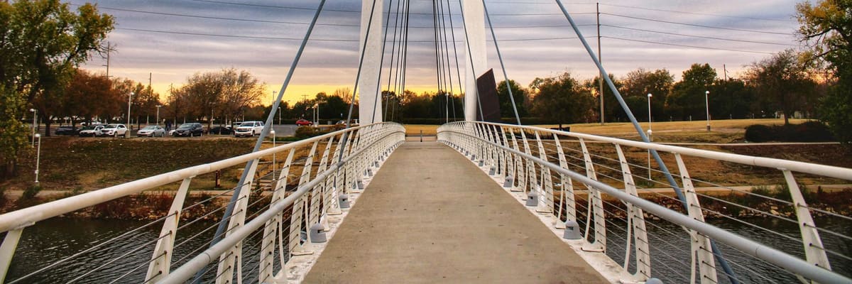 A white pedestrian footbridge at sunset in Wichita, Kansas
