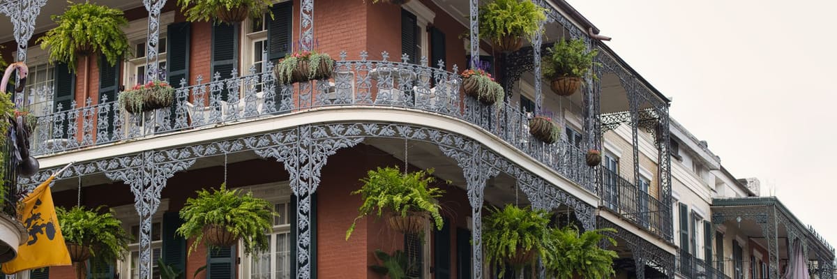 Wrought iron balconies and hanging plants on a building in the French Quarter of New Orleans, Louisiana