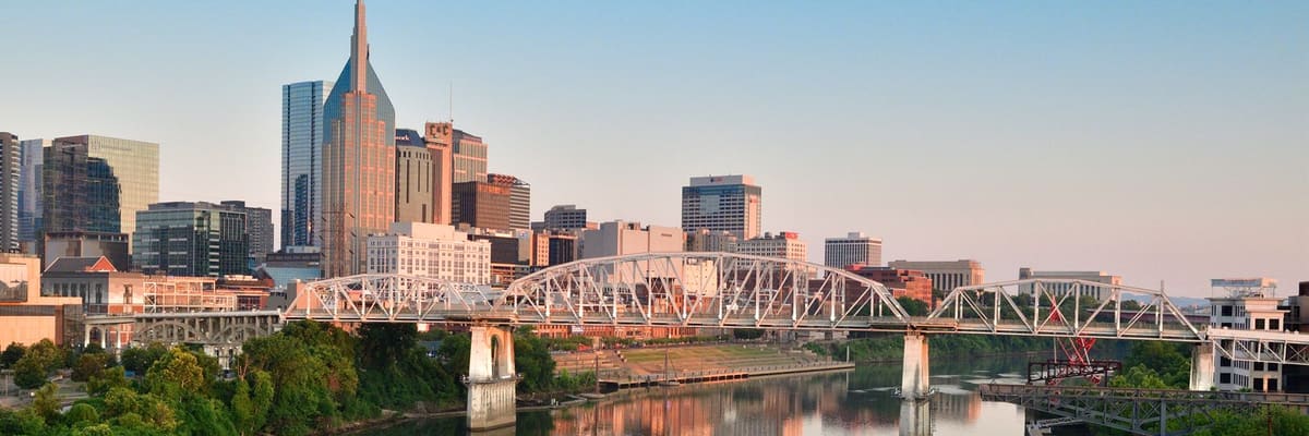 The Nashville, Tennessee skyline and a pedestrian bridge over the Cumberland River at sunrise