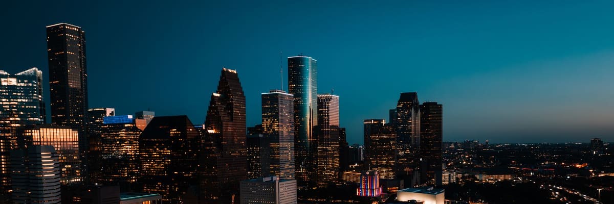 Aerial view of downtown Houston, Texas, with illuminated skyscrapers at dusk