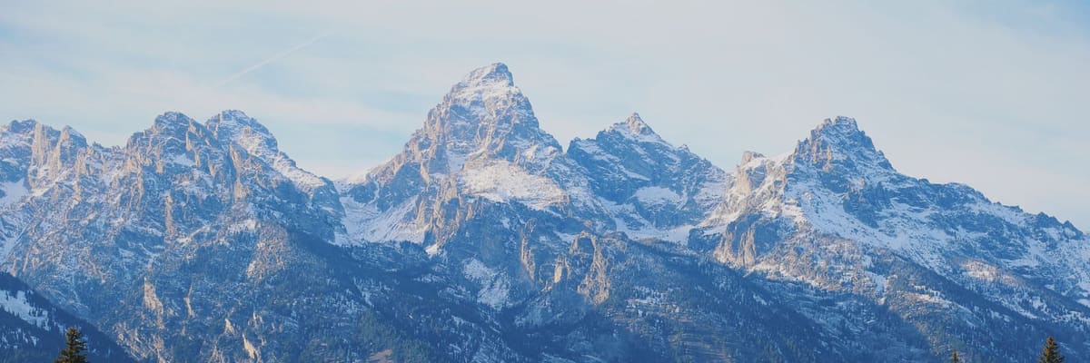 The Grand Teton mountain range in Wyoming above evergreen forest