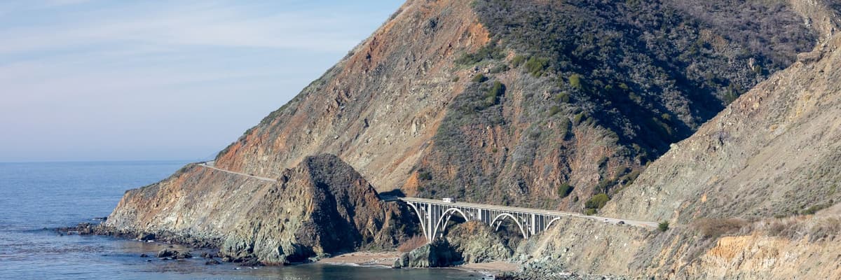 Big Creek Bridge arching across a canyon on the Big Sur coast of California, with the Pacific Ocean beyond. The photograph opens the ranking of PsyD programs in California.