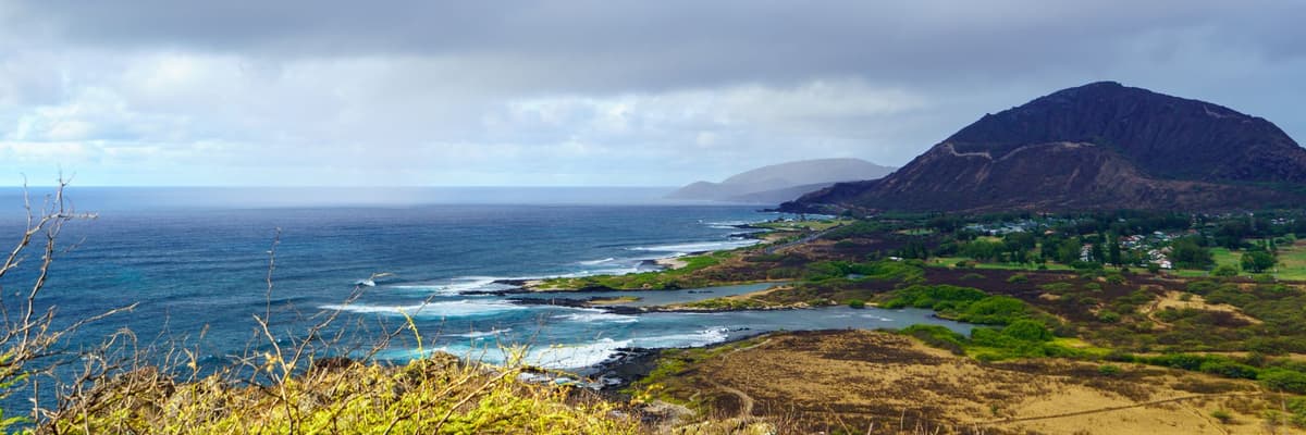 Koko Crater rising above the surf-lined Oahu coastline under heavy clouds, seen from Makapuu Point in Hawaii. The photograph opens the ranking of PsyD programs in Hawaii.