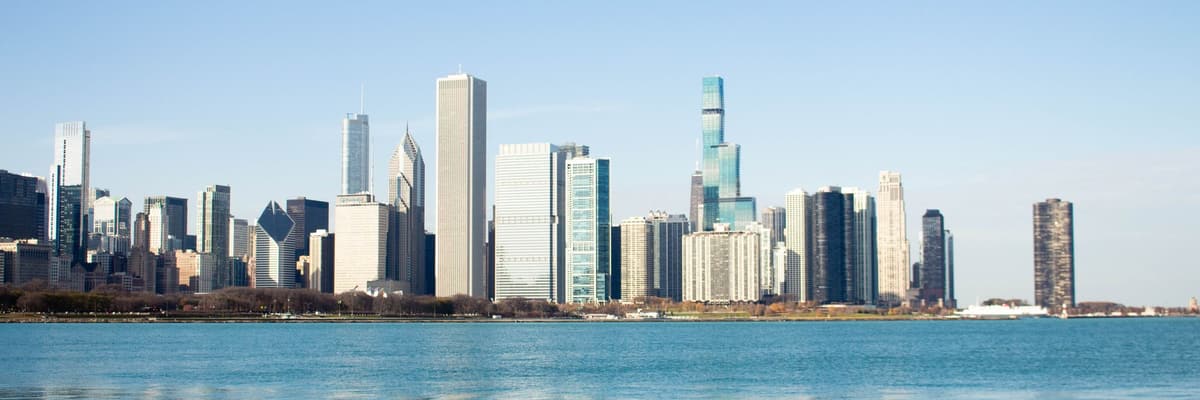 The Chicago, Illinois skyline seen across the blue water of Lake Michigan on a clear day. The photograph opens the ranking of PsyD programs in Illinois.