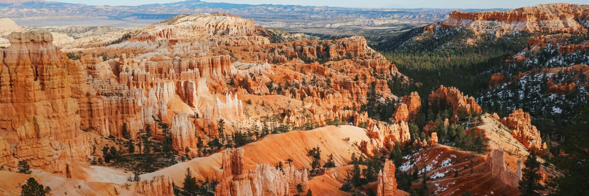 Orange hoodoos and canyon walls under a blue sky at Bryce Canyon National Park in Utah. The photograph opens the ranking of PsyD programs in Utah.